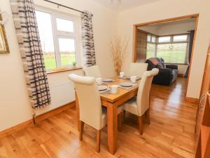 a dining room with a wooden table and chairs at Moybella Lodge in Ballybunion