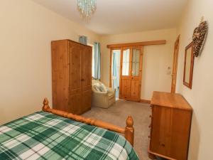 a bedroom with a bed and a wooden cabinet at Moybella Lodge in Ballybunion
