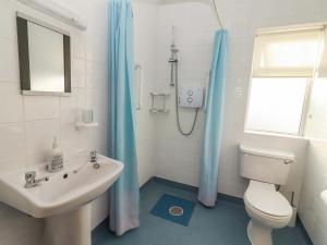 a white bathroom with a toilet and a sink at Moybella Lodge in Ballybunion +18 photos