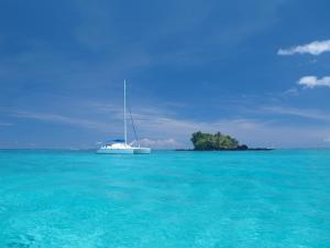 a sail boat in the ocean with a small island at Vacala Bay Resort in Matei +9 photos