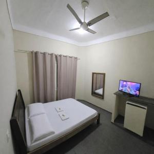 a hospital room with a bed and a flat screen tv at Estação Pousada e Hostel in Cataguases