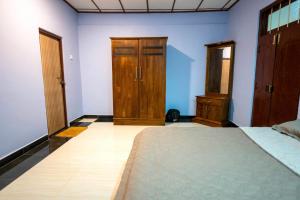a bedroom with a bed and wooden doors and a floor at Villa in Kalviyankadu in Irupalai