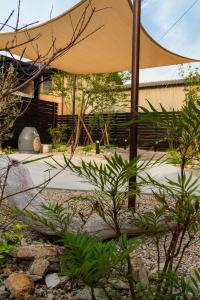a large umbrella in a garden with plants at いとしま風遊 in Itoshima