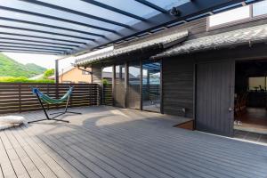 a patio with a hammock on a wooden deck at いとしま風遊 in Itoshima +40 photos