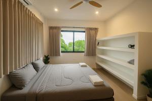 a bedroom with a large bed and a window at Villa Narkis in Haad Yao