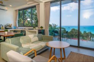 a living room with a couch and a view of the ocean at Villa Narkis in Haad Yao