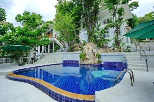 a swimming pool in front of a house at Villa Narkis in Haad Yao