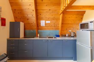 a kitchen with blue cabinets and a white refrigerator at Wetland View Park in Anatori