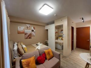 a living room with a couch with colorful pillows at Jade's Place Condo in Bacolod