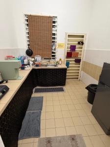 a kitchen with a sink and a tiled floor at ZARA Homestay in Marang