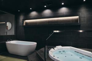 a bathroom with a bath tub and a bath tub at 白金はなれ in Susakiuramachi