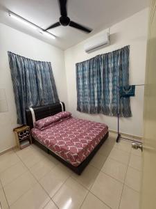 a bedroom with a bed and a ceiling fan at ZARA Homestay in Marang