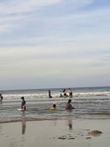 a group of people in the water at the beach at Hotel Hải Âu in Kỳ Trân (1)