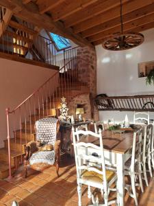 a dining room with a table and chairs and a staircase at maison la Bambine chambre esprit château in Ozolles
