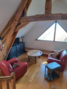a living room with a large window and red chairs at maison la Bambine chambre esprit château in Ozolles
