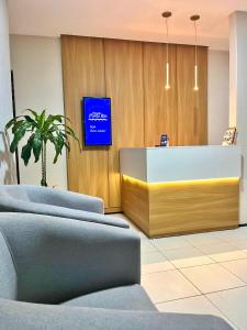 a lobby with a reception desk and a tv at Pousada Porto Rio in Parnaíba