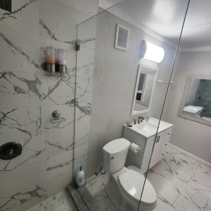 a bathroom with a toilet and a glass shower at Private and beautiful room for vacation in Carver Ranches