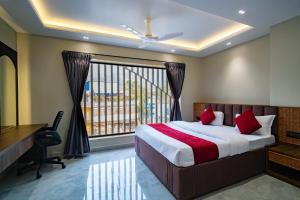 ein Schlafzimmer mit Bett, Schreibtisch und Fenster in der Unterkunft Hotel Vianta Jaigaon- Near Bhutan Border in Jaigaon