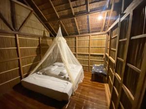 a bedroom with a bed in a room with wooden floors at Isiie Homestay in Merpati