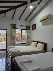 a bedroom with two beds and a window at Ibis in Udawalawe +215 photos