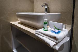 ein Badezimmer mit Waschbecken und Toilette mit Handtüchern in der Unterkunft Hotel Vianta Jaigaon- Near Bhutan Border in Jaigaon + 46 Fotos