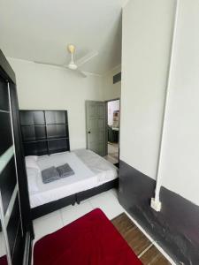 a bedroom with a bed and a red rug at Homestay nakhoda Sitiawan in Lumut