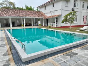 a swimming pool in front of a house at White House Tangalle in Tangalle