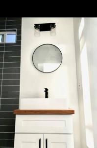a bathroom with a mirror and a white sink at Joshua Tree Tiny Home - Remote & Modern Container Home on 5 Acres in Joshua Tree