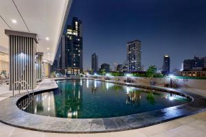 a large pool with a city skyline in the background at The Four Wings Hotel Bangkok in Bangkok