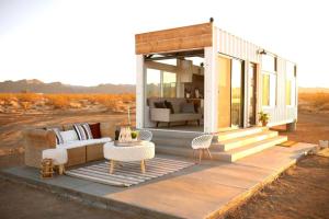 a house with a couch and a table on a deck at Joshua Tree Tiny Home - Remote & Modern Container Home on 5 Acres in Joshua Tree