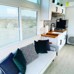 a living room with a couch with pillows on it at Joshua Tree Tiny Home - Remote & Modern Container Home on 5 Acres in Joshua Tree