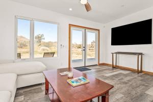 a living room with a couch and a tv at Santorini with Stargazing - Views - Spa - Fire pit in Yucca Valley