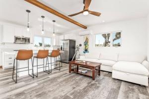 a living room with a white couch and a table at Santorini with Stargazing - Views - Spa - Fire pit in Yucca Valley