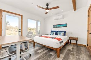 a bedroom with a bed and a table and chairs at Santorini with Stargazing - Views - Spa - Fire pit in Yucca Valley +28 photos