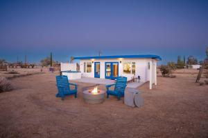 a house with two blue chairs and a candle in front of it at Santorini with Stargazing - Views - Spa - Fire pit in Yucca Valley