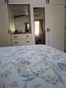 a bedroom with a bed with a blue and white blanket at Stay with Sheena - Homestay Experience in Nadi