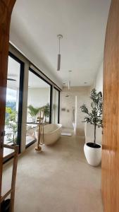 a bathroom with a tub and a tree in it at Mountainparkbali in Baturaja