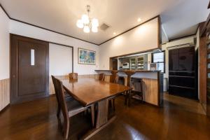 a dining room with a table and a kitchen at Tabiudo Souwa in Takayama