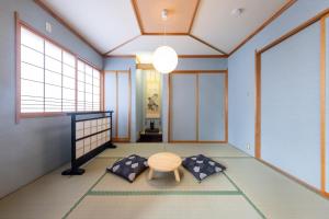 a japanese room with a table and two pillows at Tabiudo Souwa in Takayama