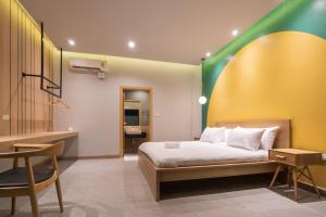 a bedroom with a bed with a green and yellow wall at The Moon Huahin Pool Villa in Hua Hin +47 photos