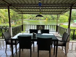 a dining room with a table and chairs on a deck at TopCats Fishing Resort in Taling Ngam Beach