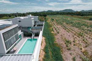 an aerial view of a house with a swimming pool and a field at The Moon Huahin Pool Villa in Hua Hin
