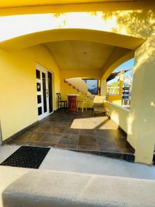 a yellow house with a patio with a table and chairs at Bungalows Las Palmas Cabo Pulmo in Cabo Pulmo