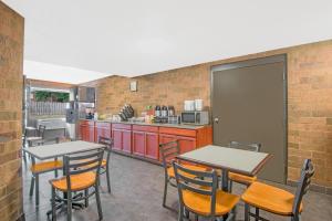 a kitchen with two tables and chairs in a room at Skylight Inn Willoughby - Cleveland Mentor in Willoughby