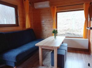 a living room with a couch and a wooden table at Pod Niedźwiedzicą in Olszyniec +6 photos