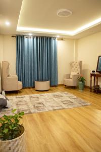 a living room with a blue curtain and two chairs at Zen Space in Kathmandu