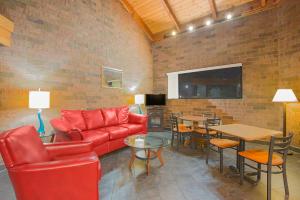 a living room with a red couch and a table at Skylight Inn Willoughby - Cleveland Mentor in Willoughby