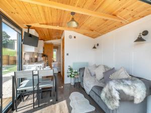 a living room with a couch and a dining room at Barn Owl Lodge - Uk49903 in Appley Bridge