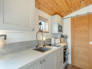 a kitchen with white cabinets and a sink at Barn Owl Lodge - Uk49903 in Appley Bridge