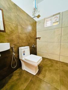 a bathroom with a toilet and a sink at Neelees Retreat in Kaniyāmbetta